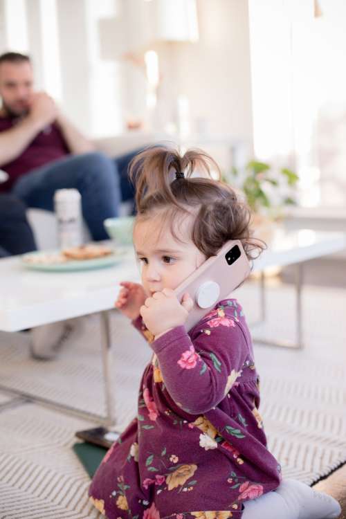 Young Child Holding A Conversation On A Pink Cell Phone Photo