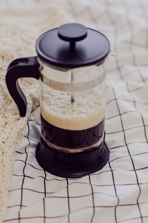 French Press With Frothy Black Coffee On White Blanket Photo