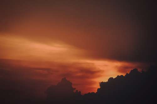 Red And Orange Sky At Sunset Silhouetting Clouds Photo