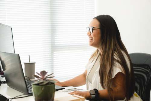 Woman Wearing Glasses By Her Desktop Monitor Photo