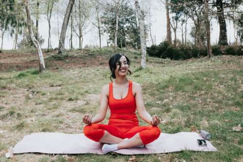Woman Smiles While Sitting In A Yoga Pose Photo