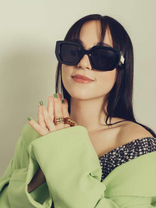 Woman In Large Black Sunglasses And A Green Shirt Photo