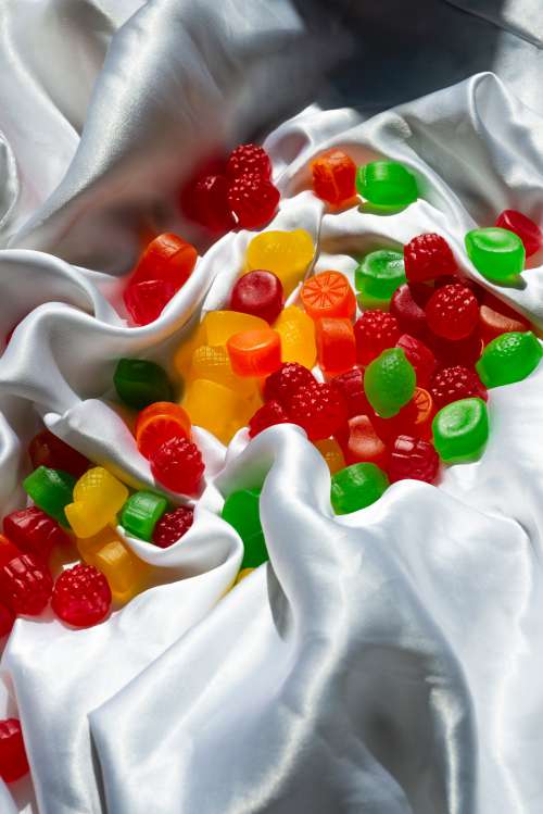 Colorful Jube Jubes Scattered On A White Silk Sheet Photo