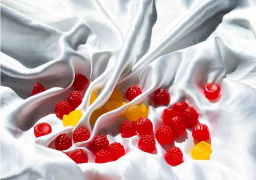 Red And Yellow Candy In The Folds Of White Silk Photo