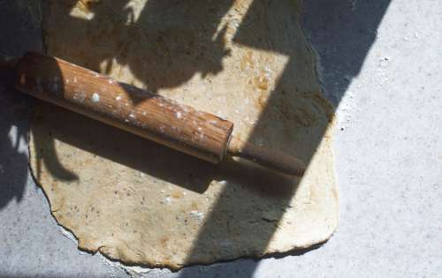 Wooden Rolling Pin Lays On Top Of Rolled Out Dough Photo