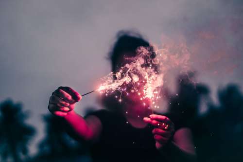 Person Holds Sparklers Out Blocking Their Face Photo