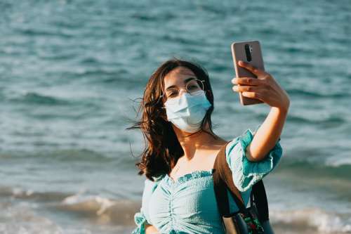 Woman In A Facemask Takes A Selfie With Her Phone Photo