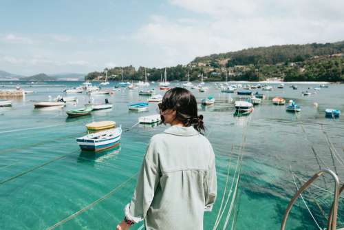 Person Looks Out To Aqua Blue Water Filled With Boats Photo