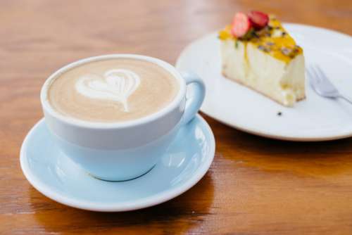 Latte and a cheesecake on a café table
