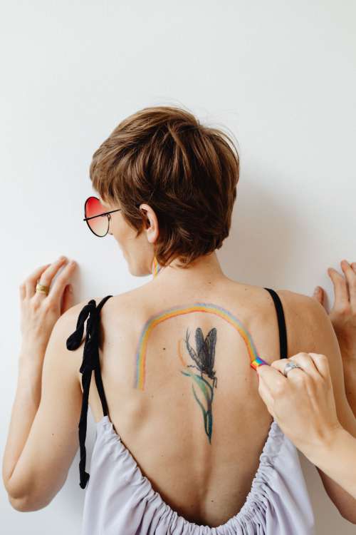 Girls paint an LGBT rainbow on their bodies