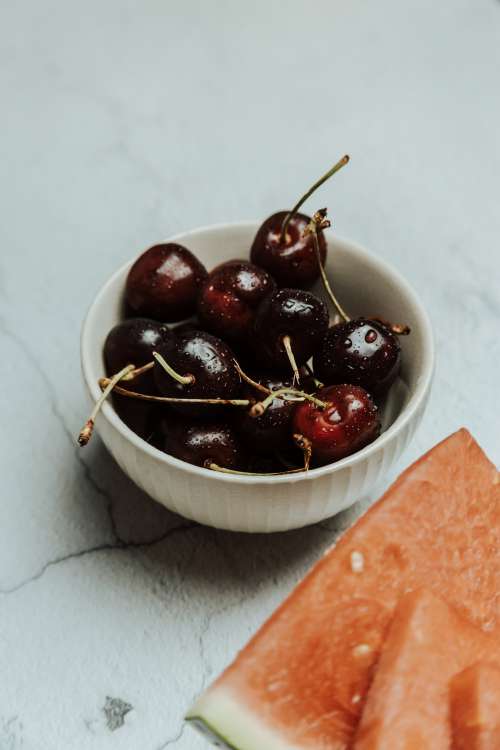 Small White Bowl Filled With Ripe Cherries Photo