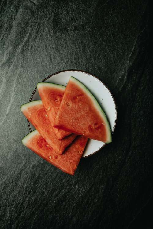 Sliced Watermelon Fanned Out On A White Plate Photo