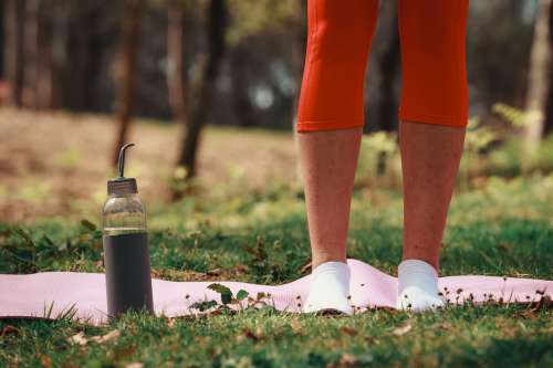 Legs Standing On A Pink Yoga Mat Outdoors Photo