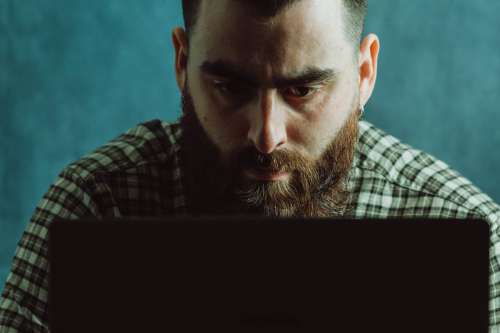 Man In Deep Concentration Looks Down At A Laptop Photo