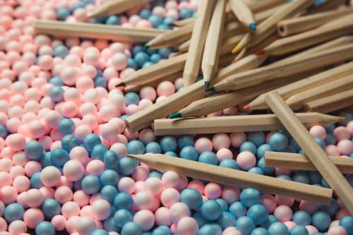 Colored Pencils Scattered On Pink And Blue Balls Photo