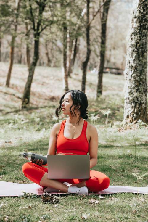 Woman In Vibrant Red Works On Her Laptop Outdoors Photo