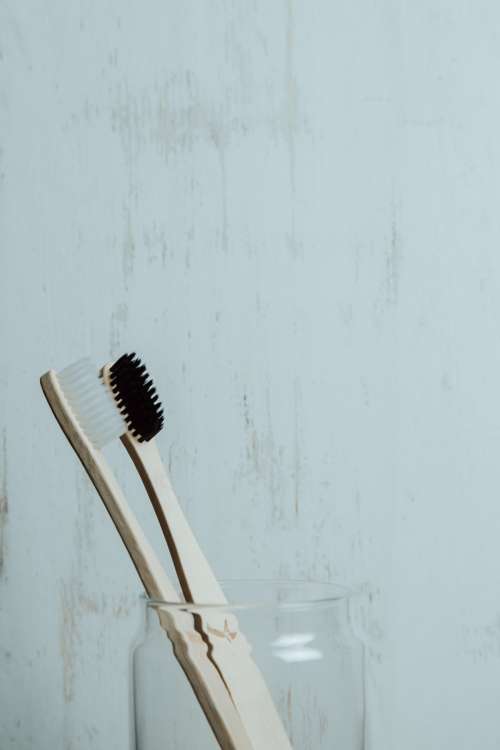 Black And White Wooden Toothbrushes In A Glass Cup Photo