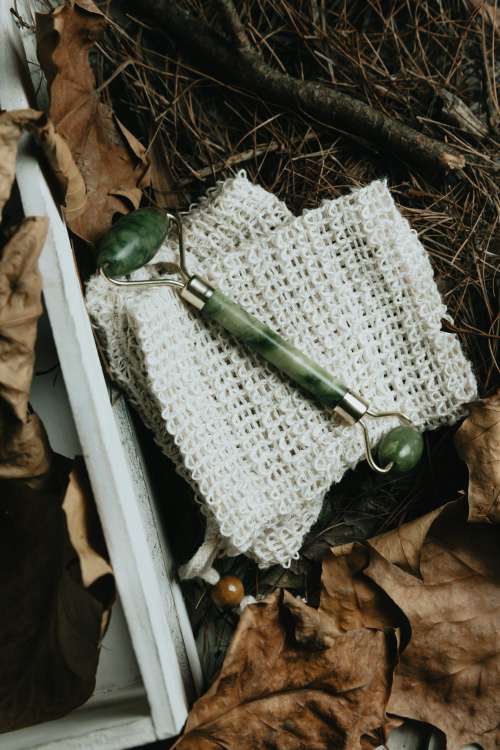 Jade Face Roller Flatlay Surrounded By Dried Leaves Photo