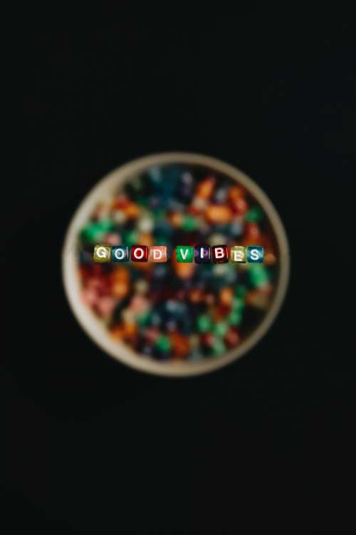 Colorful Beads Float Above A Bowl And Read Good Vibes Photo