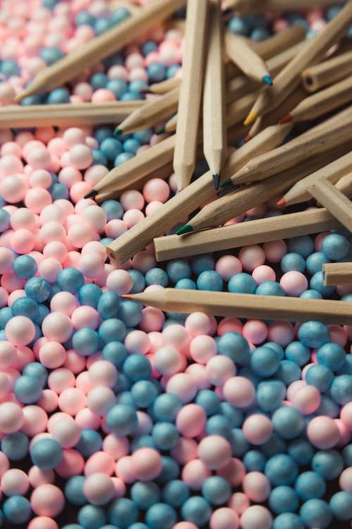 Wooden Colored Pencils Scattered On Pink And Blue Balls Photo
