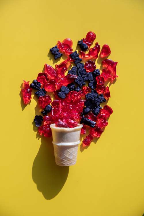 Red And Black Gummies Spill Out Of An Icecream Cone Photo