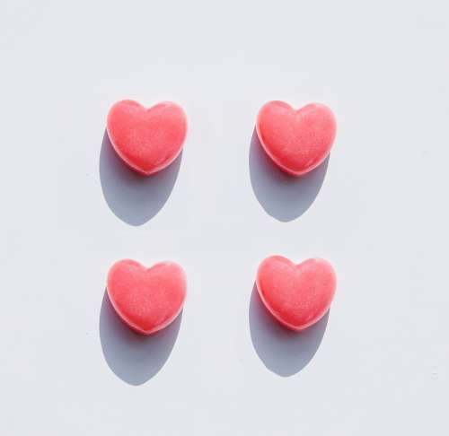 Four Hearts Lay Spaced Out On A White Background Photo