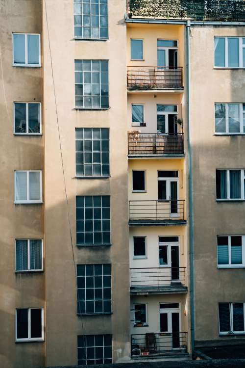 The Side Of A Yellow Buildings With Balconies And Windows Photo