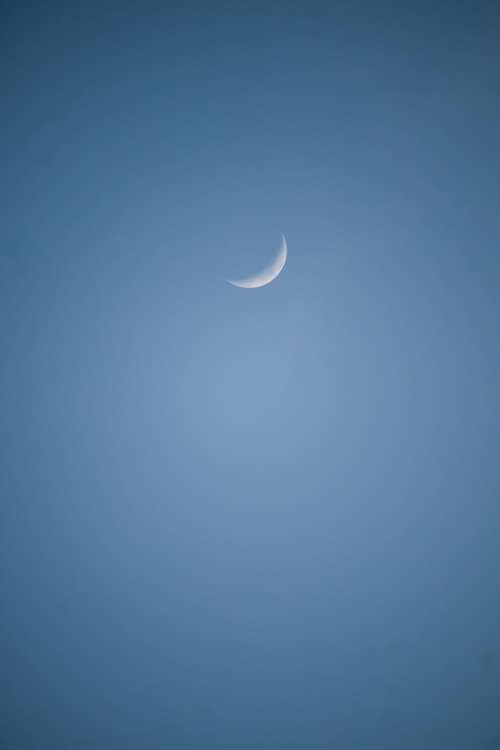 Small Sliver Of The Moon In A Blue Sky Photo
