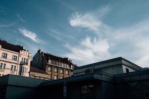 Blue Skies With Wispy Clouds Over Building Rooftops Photo