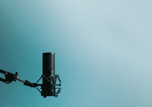 Microphone On Stand Left Of Frame Against Blue Photo