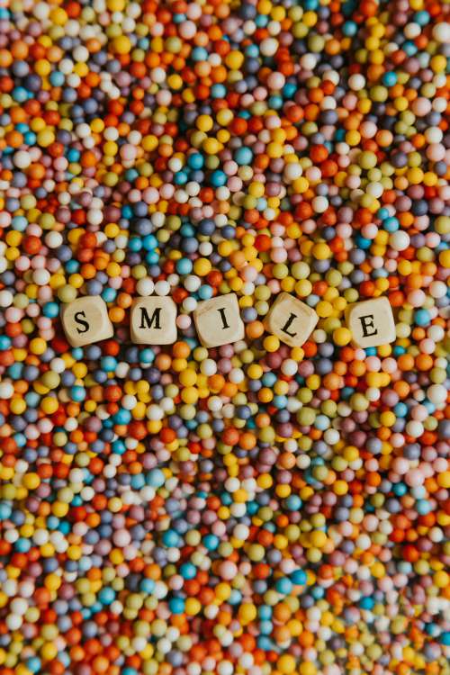 Wooden Block Spell Out Smile Laying On Colorful Dots Photo