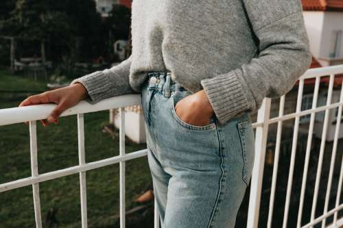 Persons Torso And Jeans Standing On A Balcony Photo