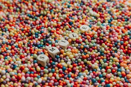 White Blocks Laying In Colorful Dots Spells Out Smile Photo