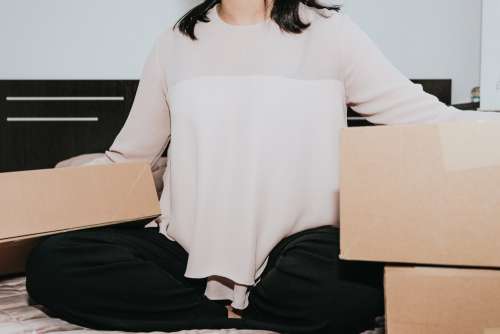 Person Sitting With Large Cardboard Boxes Photo