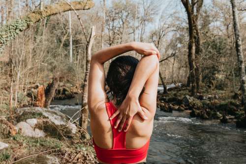 Person In Red Holds Their Arm In A Stretch Outdoors Photo