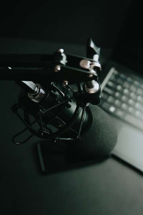 Black Tilted Microphone And A Computer Keyboard Photo