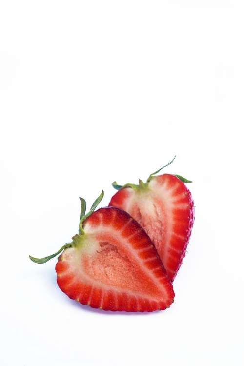 Ripe Strawberry Cut In Half On A White Surface Photo