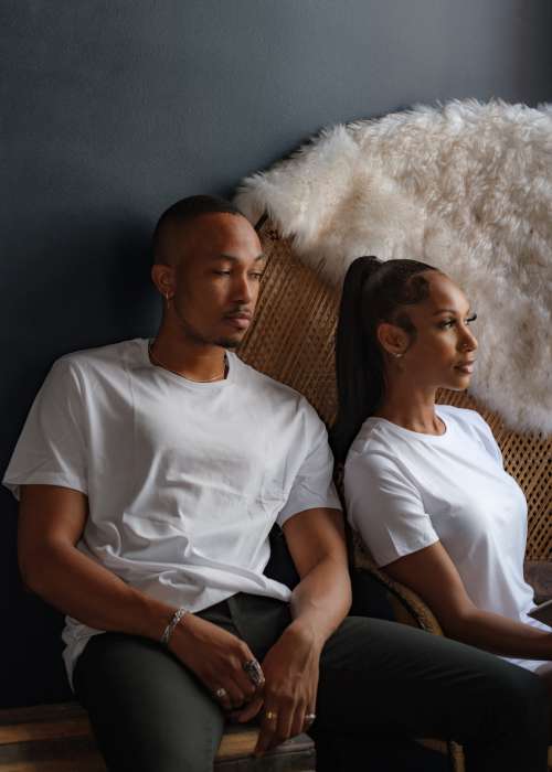 Two People In Tshirts Sit By A Black Wall Photo