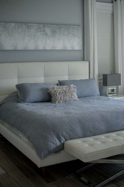 Photo Of A Bed With A White Bed Frame And Blue Sheets Photo