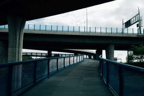 Walkway Under Large Concrete Overpass Photo