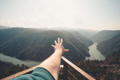 River And Hills With A Hand Reaching Outwards Photo