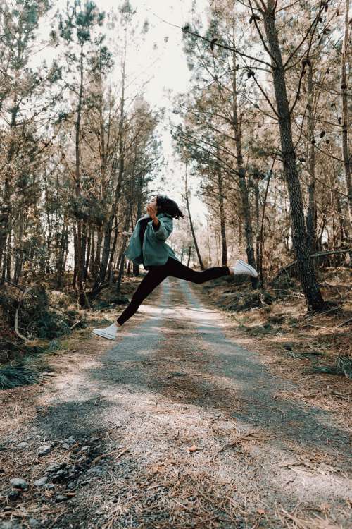 A Person Mid Jump On A Country Road Photo