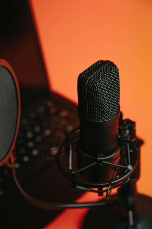 Black Microphone On A Stand Reflecting Orange Light Photo