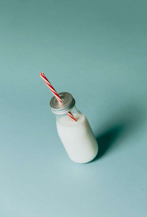 Bottle Of Milk With Silver Lid And Red Striped Straw Photo