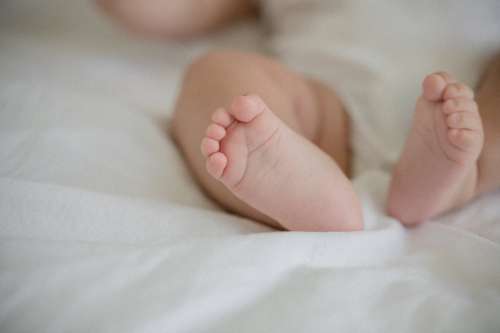 Small Feet Of A Baby On A White Sheet Photo