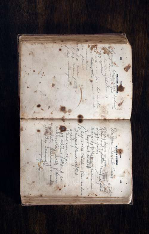 Handwritten Cookbook Lays Open On A Wooden Surface Photo
