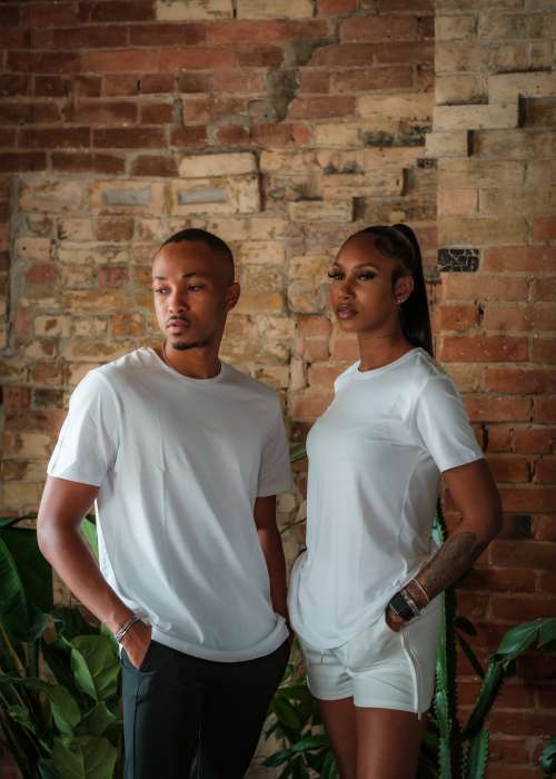 Two Models In White Stand In Front Of Red Brick Photo