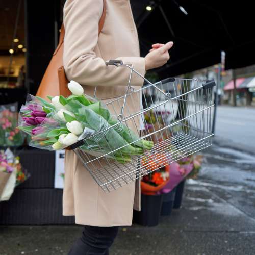 Person Holds A Shopping Basket With Purple And White Tulips Photo