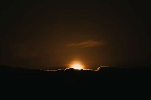 Sunsets Behind A Cloud In A Dark Night Sky Photo