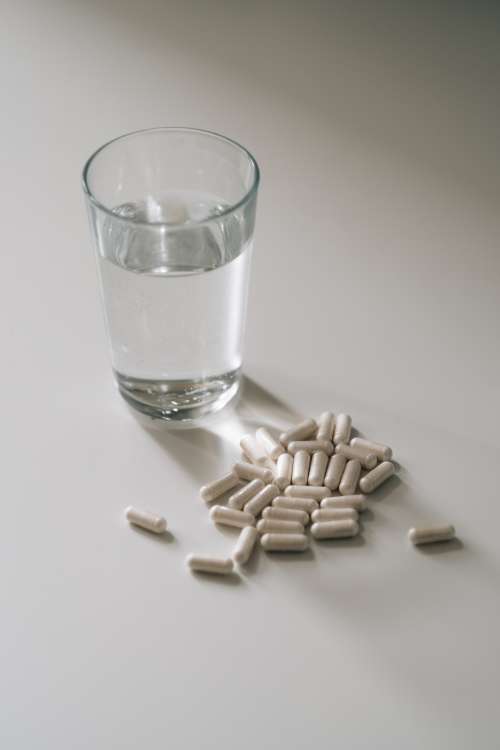 Glass Of Water And A Pile Of White Pills Photo